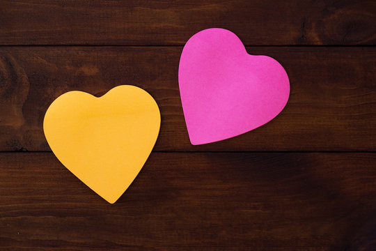 Colorful heart shaped paper on wooden board. Mock up for designers.