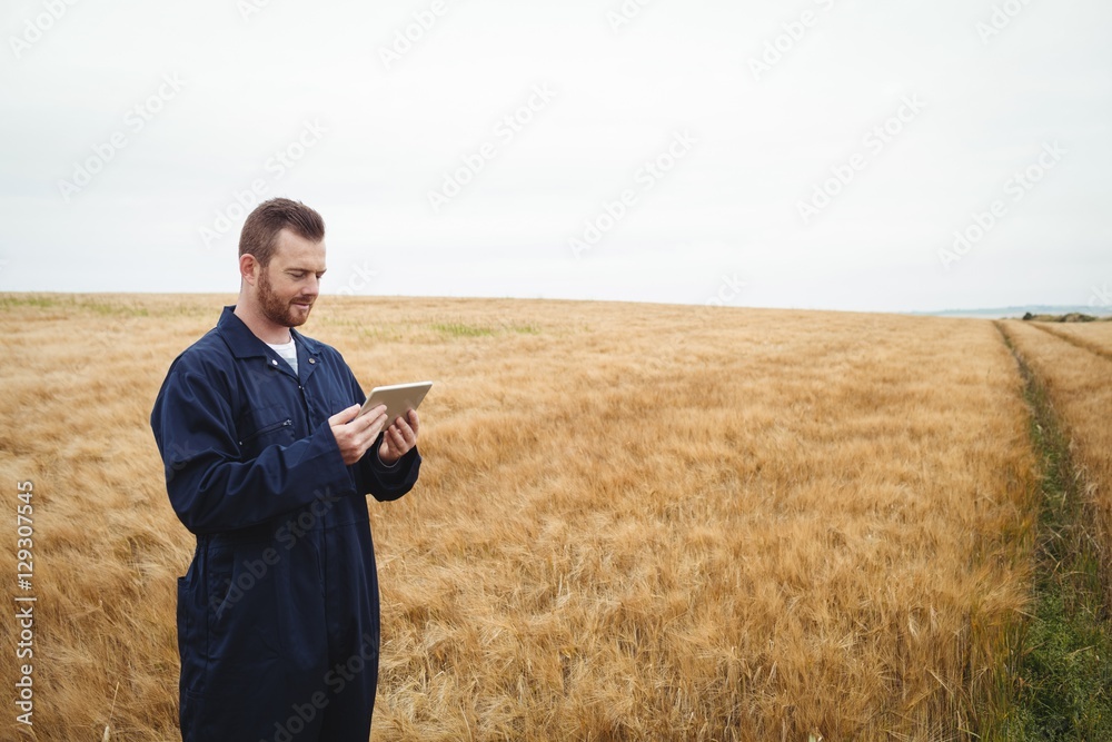 Poster farmer using digital tablet in the field