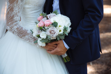 Wedding bouquet in marriage couple hands