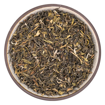 Organic green tea darjeeling in ceramic bowl isolated on white background, top view
