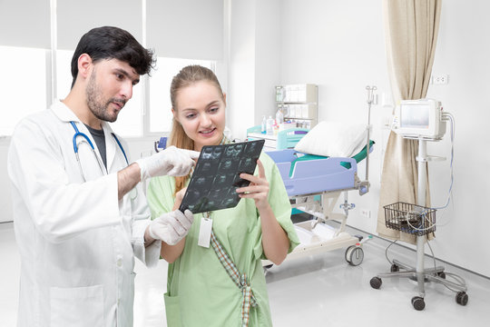 Doctor examining an x-ray film and discussing with a patient 