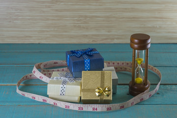 Hourglass with the tape and giftsbox measure shows the weight control.it take