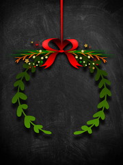 Green garland ornament hanged by red Christmas ribbon against blackboard background