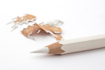 White colored pencil with pencil shavings on white background