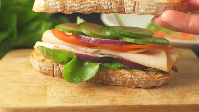 Preparing a sandwich with ham and vegetables