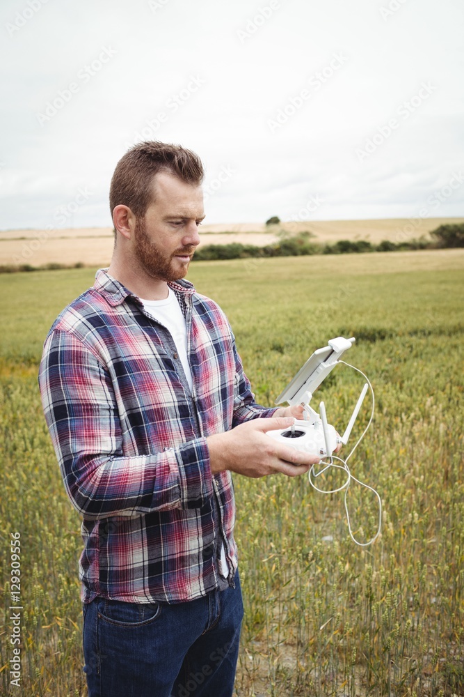 Poster Farmer using agricultural device while examining in field