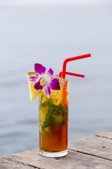 Refreshing drink with lime, mint and pineapple on a tropical beach