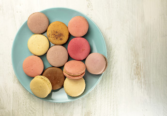 Photo of macarons on teal blue plate with copyspace
