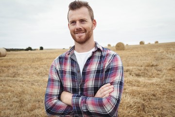 Farmer standing with arms crossed in the field