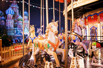 Fototapeta na wymiar Carousel horses at the Christmas Fair on the background of St. B