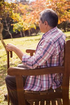  Elderly Man Sitting On Bench With His Cane