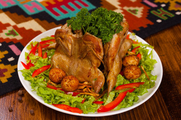 Chicken Tabaka with parsley, potatoes and lettuce on a white plate