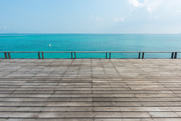 Fototapeta na wymiar wooden floor with beautiful ocean and blue sky scenery