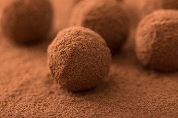 Close up of group of appetizing black chocolate truffles covered