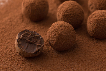 Close up of group of appetizing black chocolate truffles covered