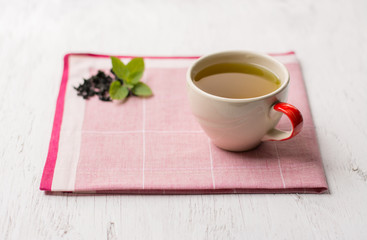 Closeup Herbal peppermint tea outdoor summer green leaves,Tea cup with mint leaves on wood background.