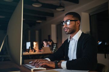 Concentrated african businessman working late at night