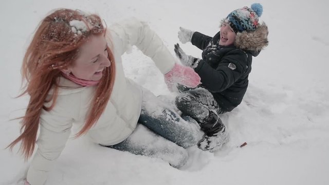 mother and son having fun in the snow wonderful winter day