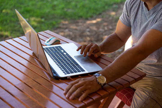 Man outdoors with laptop computer working on vacation