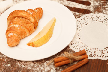 pear and croissant in coconut chips are a wooden background