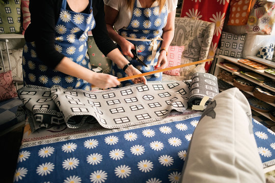 Midsection of owners working on textile in fabric shop