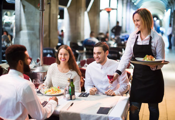 Obraz premium Smiling friends in outdoors restauran