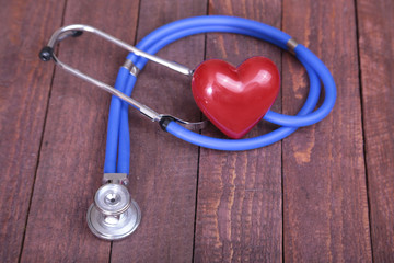 Heart with a stethoscope, isolated on wooden background