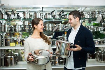 Fototapeta na wymiar Couple buying pans in shop cookware.