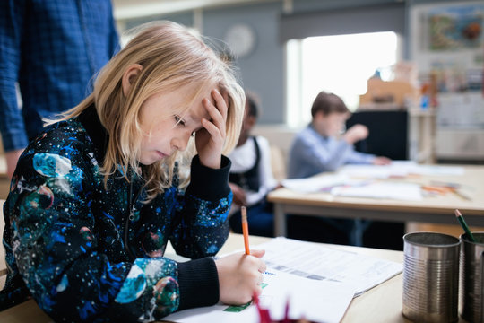 Concentrated girl studying at table in classroom