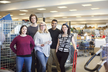 Portrait of smiling volunteers standing in workshop