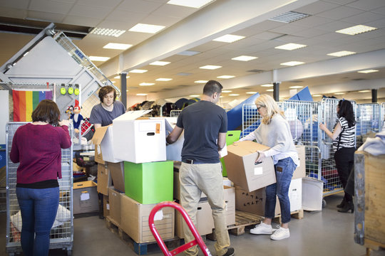 Volunteers arranging cardboard boxes while working in workshop