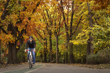 Obraz premium Man with his bike enjoying driving in park in autumn time, with