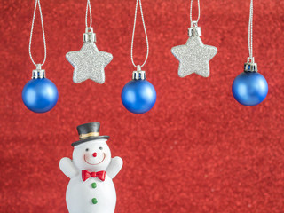 Silver star and blue christmas ball hang on red blur background