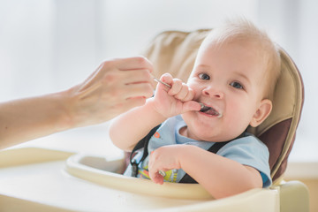mother feeding her baby breast porridge day