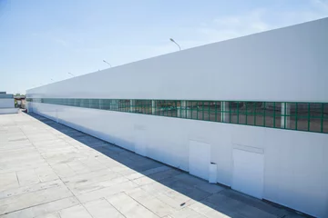 Lichtdoorlatende rolgordijnen Industrieel gebouw facade of an industrial building and warehouse in length