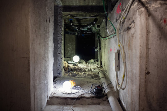 Illuminated lights on floor in messy corridor at construction site