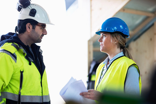 Managers discussing over document at construction site
