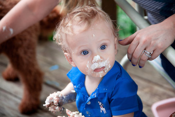Obraz premium Young Caucasian boy celebrates his first birthday making a mess