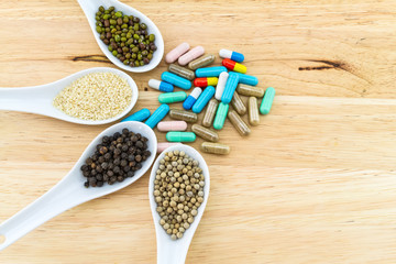 Green bean , white sesame ,black and white pepper  and colorful pill on wooden