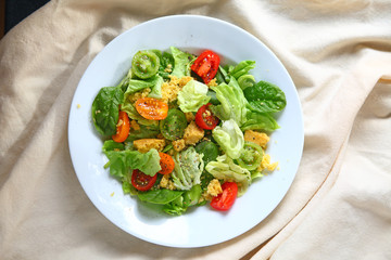 Overhead view of salad with cherry tomatoes and cornbread