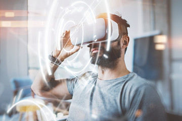 Concept of digital screen,connection and interfaces.Young beraded hipster enjoyingvirtual reality...
