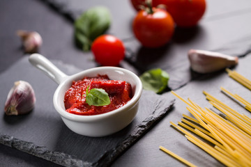 Food ingredients for Italian spaghetti on black stone slate background. Vegetarian version of pasta.