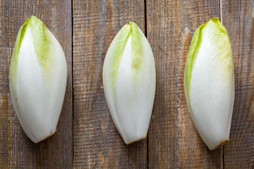 Top view on endive lying on wooden background.