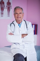 Portrait of physiotherapist sitting with arms crossed