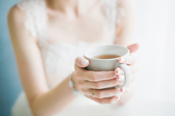 Bride drinking tea from a white cup