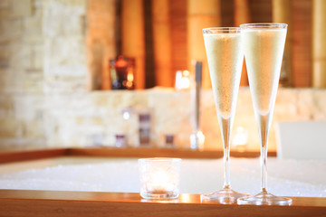Two glasses of champagne with candle near jacuzzi. Valentines ba