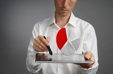 Man in white shirt working with pie chart on a tablet computer, application for budget planning or...