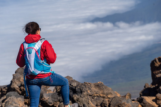 Female hikers enjoying scenic view of Teide National Park, Tenerife, Canary Island. Hiking high above clouds in 3000 meter above sea level.