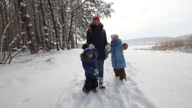 Mother walks with children in the winter woods
