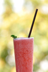 Strawberry smoothie in long glass with lighting bokeh.